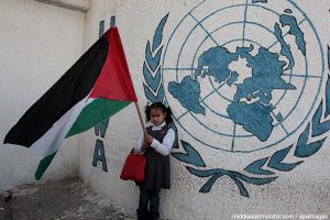 palestinian-girl-with-flag-in-front-on-unrwa-logo